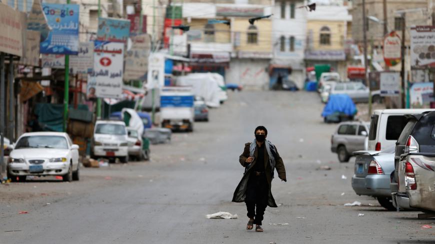 A security man wearing a protective mask walks on a street during a 24-hour curfew amid concerns about the spread of the coronavirus disease (COVID-19), in Sanaa, Yemen May 6, 2020. REUTERS/Khaled Abdullah - RC25JG9B0IDA