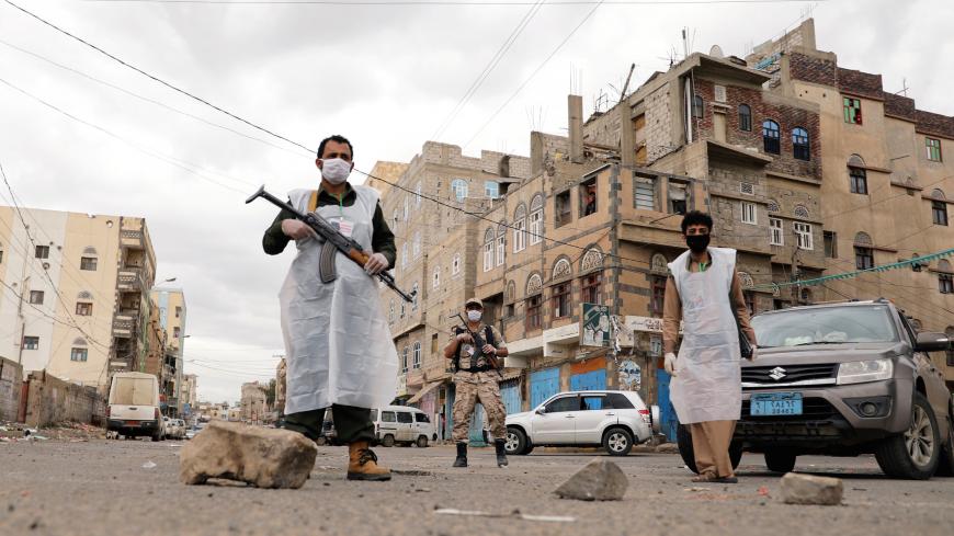 Security men wearing protective masks stand on a street during a 24-hour curfew amid concerns about the spread of the coronavirus disease (COVID-19), in Sanaa, Yemen May 6, 2020. REUTERS/Khaled Abdullah     TPX IMAGES OF THE DAY - RC25JG9N8EU1