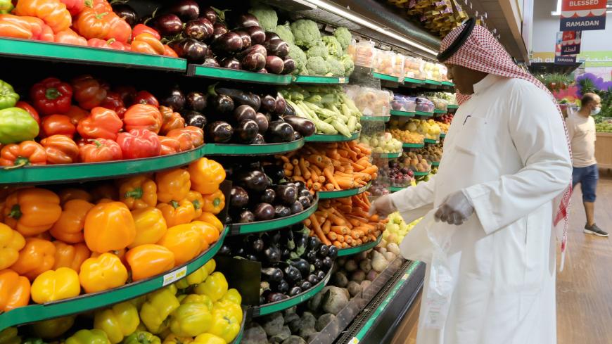 A Saudi man wearing protective gloves buys vegetables at a supermarket, following the outbreak of the coronavirus disease (COVID-19), in Riyadh, Saudi Arabia May 11, 2020. REUTERS/Ahmed Yosri - RC2DMG9SBKB9