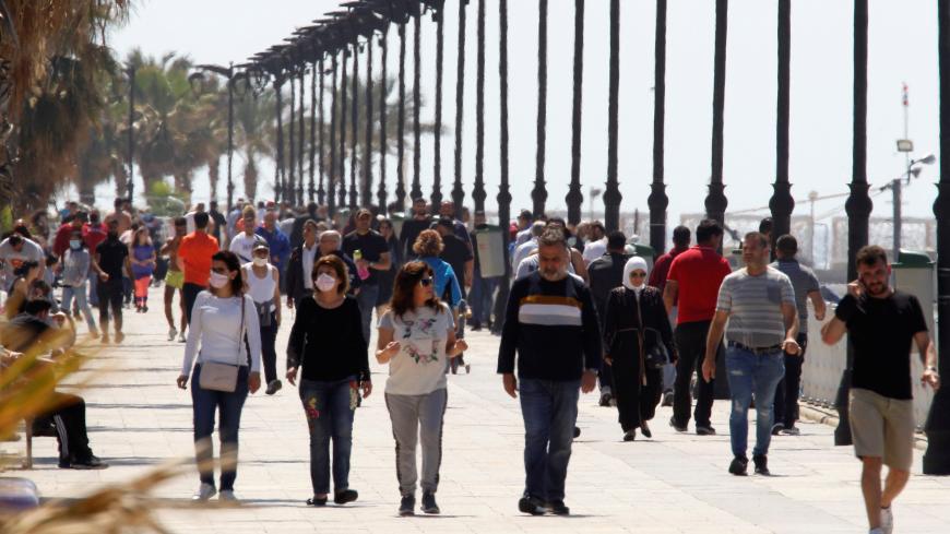 People walk along Beirut's seaside Corniche, as Lebanese authorities warned of a new wave of the coronavirus disease (COVID-19) as the numbers jumped to the highest point in more than a month, after the government eased some restrictions on public life, in Beirut, Lebanon May 10, 2020. Picture taken May 10, 2020. REUTERS/Mohamed Azakir - RC2FMG9YAZYS