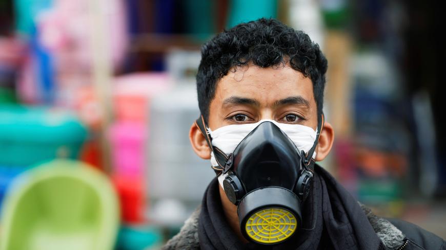 A man wears a protective face mask outside a shop amid concerns over the spread of the coronavirus disease (COVID-19), in Sanaa, Yemen May 13, 2020. Picture taken May 13, 2020. REUTERS/Khaled Abdullah - RC2WQG97P6Y8