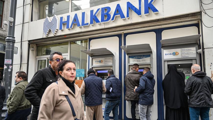 In this photograph taken on December 10, 2019, pedestrians pass in front of state run Halkbank on Istiklal Avenue in Istanbul. - At a half-built metro stop on the outskirts of Istanbul, the diggers have been idle for months, dozens of workers waiting day after day with nothing to do. The new 550-million-euro metro line, started in 2016, was due to connect outlying suburbs in the Asian side to the ferries and sealines in the centre of the city, but has been stalled as the municipality struggles to raise fund