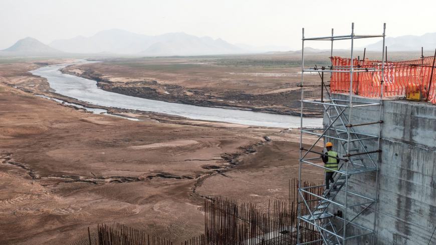 A worker goes down a construction ladder at the Grand Ethiopian Renaissance Dam (GERD),   near Guba in Ethiopia, on December 26, 2019. - The Grand Ethiopian Renaissance Dam, a 145-metre-high, 1.8-kilometre-long concrete colossus is set to become the largest hydropower plant in Africa.
Across Ethiopia, poor farmers and rich businessmen alike eagerly await the more than 6,000 megawatts of electricity officials say it will ultimately provide. 
Yet as thousands of workers toil day and night to finish the projec