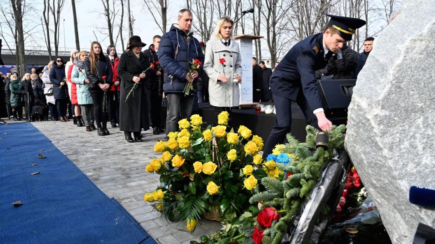 Relatives and colleagues of the 11 Ukrainians who died in a plane mistakenly shot down by Iran in January, lay flowers during a ceremony unveiling a memorial stone at the site of the future monument at the Boryspil International airport outside Kiev on February 17, 2020. (Photo by Sergei SUPINSKY / AFP) (Photo by SERGEI SUPINSKY/AFP via Getty Images)