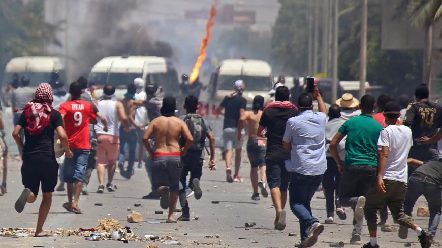 TOPSHOT - Tunisian protesters clash with security forces as they demonstrate in the southern city of  Tataouine on June 22, 2020 demanding authorities make good on a 2017 promise to provide jobs in the gas and oil sector to thousands of unemployed. - Tunisian security forces clashed for a second day with protesters demanding jobs and the release of an activist in Tunisia's marginalised south, after weeks of tensions. The protests come as Tunisia, until now largely spared the worst of the novel coronavirus, 