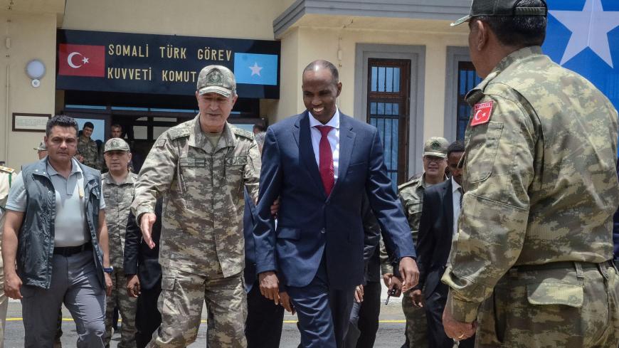 Turkish army Chief of General Staff Hulusi Akar (L) escorts Somalia Prime Minister Hassan Ali Kheire during an inauguration ceremony of the Turkish military base in Mogadishu on September 30, 2017.
Turkey inaugurated the largest foreign-run military training centre in Somalia, where local troops are due to take over the protection of a nation threatened by Shabaab Islamist attacks. / AFP PHOTO / Mustafa ABDI        (Photo credit should read MUSTAFA ABDI/AFP via Getty Images)