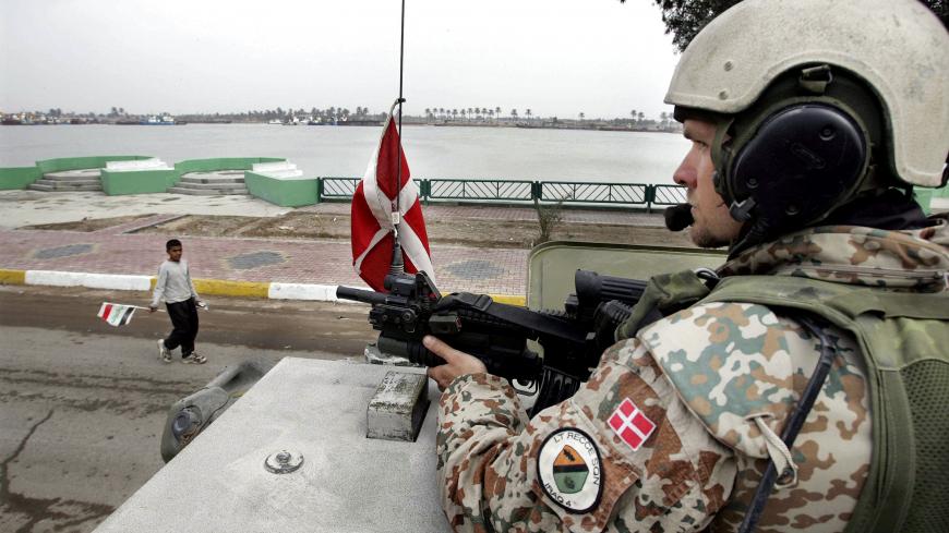 Danish troops patrol in southern Iraq in this January 2005 file photo. Denmark will withdraw all of its ground troops from Iraq by August and replace them with a small helicopter unit, Denmark's Prime Minister Anders Fogh Rasmussen said on Wednesday.     SWEDEN OUT    NORWAY OUT    DENMARK OUT    NO THIRD PARTY SALES    REUTERS/Henning Bagger/Scanpix (IRAQ) - GM1DUQWFEIAA
