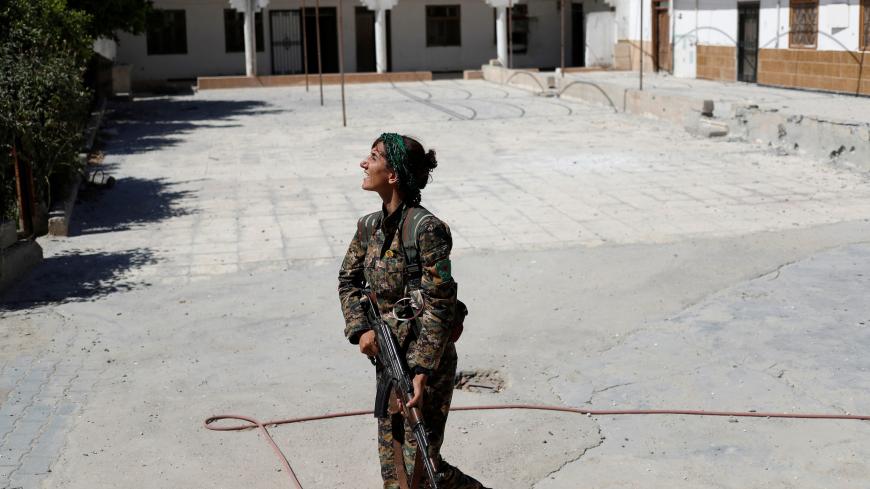 Sheen Ibrahim, Kurdish fighter from the People's Protection Units (YPG) looks for drones operated by Islamic State militants in Raqqa, Syria June 21, 2017. REUTERS/Goran Tomasevic - RC1D3CB0FA70