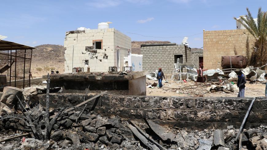 People walk at the scene of an air strike that hit a gas station near a hospital in Kutaf district of the northwestern province of Saada, Yemen March 28, 2019. REUTERS/Naif Rahma - RC1B84944380
