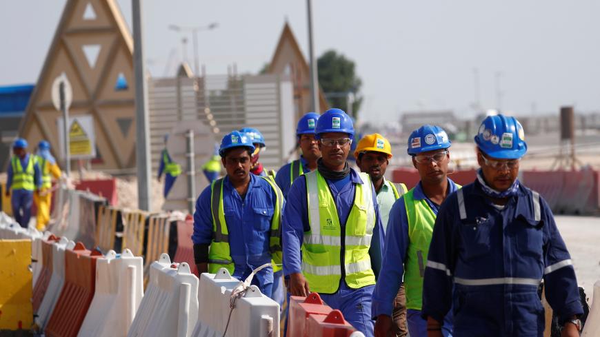 Workers walk towards the construction site of the Lusail stadium which will be build for the upcoming 2022 Fifa soccer World Cup during a stadium tour in Doha, Qatar, December 20, 2019.  REUTERS/Kai Pfaffenbach - RC2XYD9VDZOB