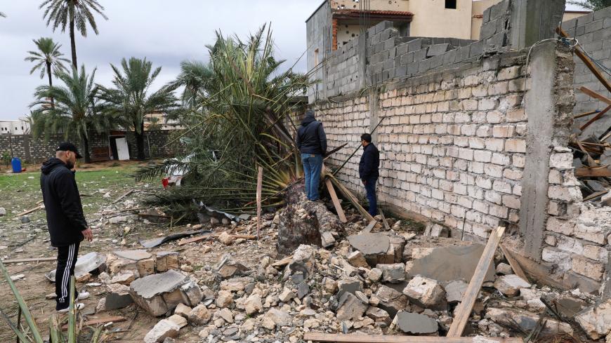 People inspect a damaged building after an air strike at Tajura neighbourhood, east of Tripoli, Libya December 30, 2019.  REUTERS/Ismail Zitouny - RC2M5E9XLQA1