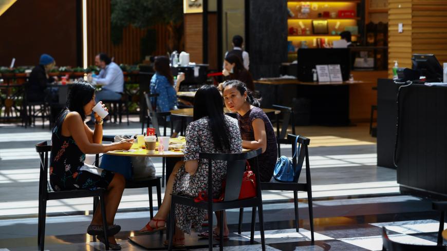 People sit in a coffee shop during the reopening of malls, following the outbreak of the coronavirus disease (COVID-19), at Mall of the Emirates in Dubai, United Arab Emirates, May 28, 2020. REUTERS/Ahmed Jadallah - RC2SXG9IIZ4G
