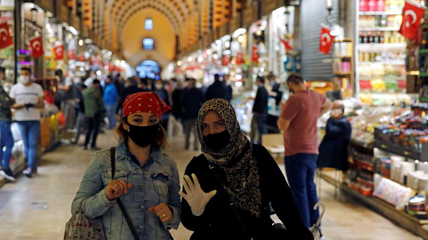 Women wearing protective face masks walk at the spice market, also known as the Egyptian Bazaar, as it reopens after weeks of the close doors amid the spread of the coronavirus disease (COVID-19), in Istanbul, Turkey, June 1, 2020. REUTERS/Umit Bektas - RC2B0H9WHBPH