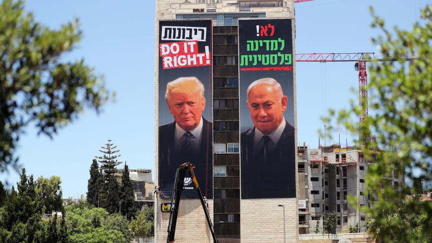 A labourer puts up banners depicting U.S. President Donald Trump and Israeli Prime Minister Benjamin Netanyahu, part of a new campaign by the umbrella Yesha Jewish settler council bearing the words in Hebrew, "No to a Palestinian State" and "Sovereignty Do it right!", in Jerusalem June 10, 2020. REUTERS/Ammar Awad - RC2B6H9W3TZP