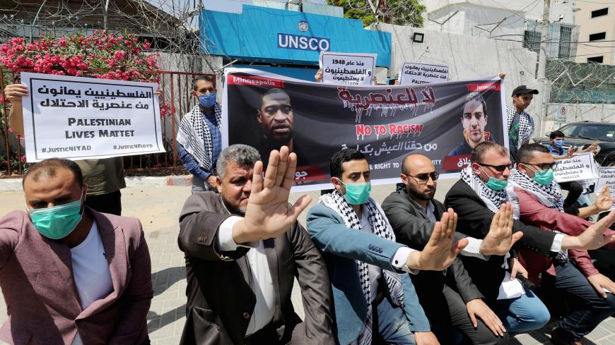 Palestinians gesture as others hold a banner with pictures of George Floyd, who died in Minneapolis police custody, and Iyad al-Halaq, an unarmed autistic Palestinian who was shot dead by Israeli police, during a protest against racial inequality, in Gaza City June 11, 2020. REUTERS/Mohammed Salem - RC2X6H9B9II7