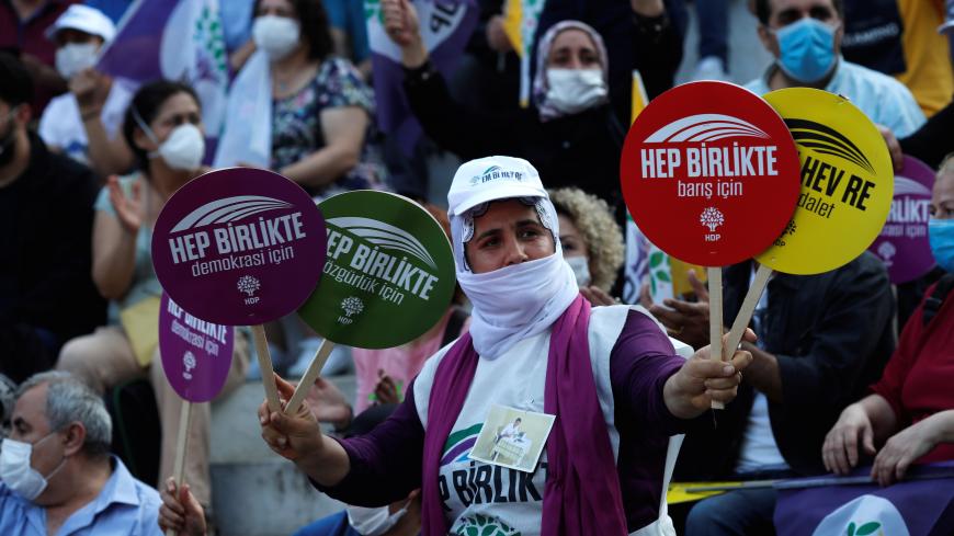 A supporter of the pro-Kurdish Peoples' Democratic Party (HDP) holds placards during a gathering as part of their "Democracy March", in Istanbul, Turkey June 18, 2020. The placards read that: "All together for democracy, freedom, peace, justice". REUTERS/Murad Sezer - RC2UBH9CTB9E