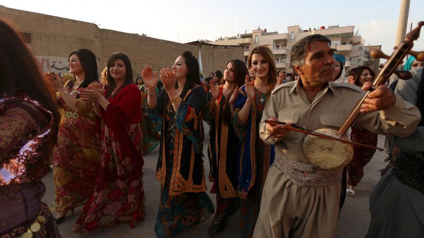 Kurdish women wearing traditional clothes dance during a celebration for Kurdish outfit day in the northeast Syrian Kurdish city of Qamishli Syria March 10, 2016. REUTERS/Rodi Said  - GF10000340960