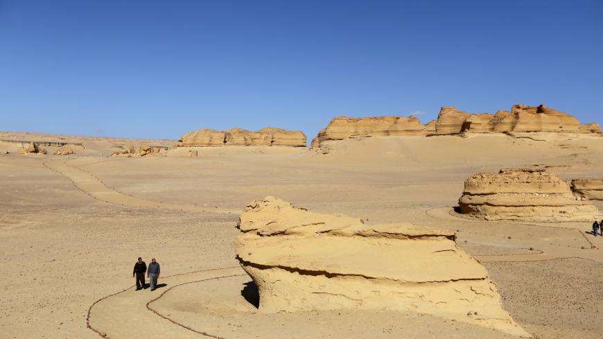 People walk around the rocks in the natural reserve area of Wadi Al-Hitan, or the "Valley of the Whales", at the desert of Al Fayoum Governorate, southwest of Cairo, Egypt, January 14, 2016.  Wadi Al-Hitan holds an impressive collection of fossils and bones, some of which date back over 40 million years. The entire site resembles an open-air museum with marked trails that visitors can follow to admire the fossils and rock formations that extend over a vast area. REUTERS/Mohamed Abd El Ghany - GF20000094784