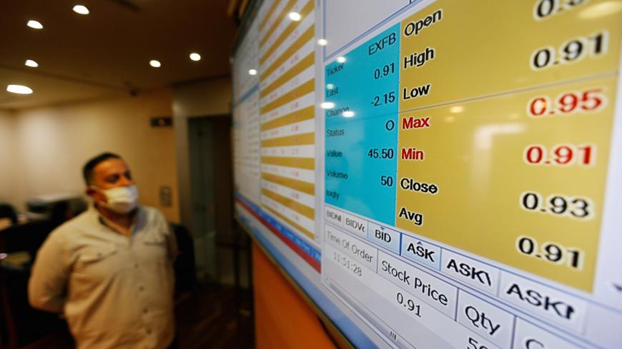 A dealer monitors price movements on an electronic board at the Amman Stock Exchange after it was reopened following 50-day halt over aimed at containing the spread of the coronavirus disease (COVID-19), in Amman, Jordan May 10, 2020. REUTERS/Muhammad Hamed - RC2OLG9OBZFQ