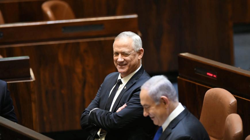 Israeli Prime Minister Benjamin Netanyahu and Benny Gantz, centrist Blue and White leader, and Netanyahu's partner in his new unity government, talk during a swearing in ceremony of the new government, at the Knesset, Israel's parliament, in Jerusalem May 17, 2020. Amos Ben Gershon/Knesset Spokesperson's Office/Handout via REUTERS THIS IMAGE HAS BEEN SUPPLIED BY A THIRD PARTY. MANDATORY CREDIT - RC2FQG9FD46U