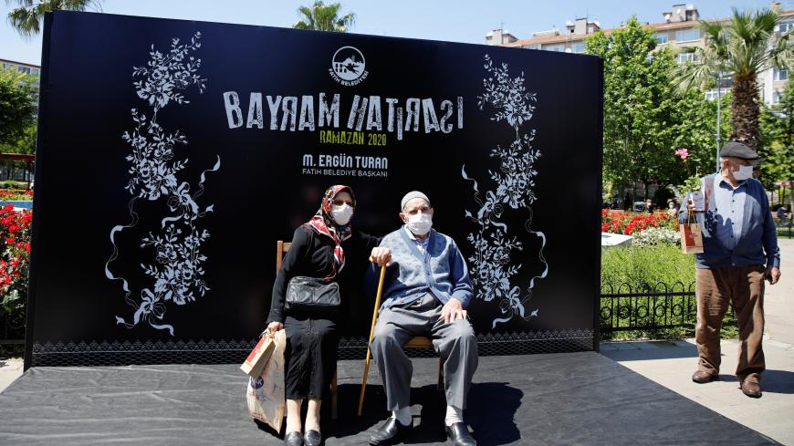 An elderly couple poses for a picture at a park, as seniors over 65 years old have been exempted from curfew for six hours during the first day of Eid, amid the spread of the coronavirus disease (COVID-19), in Istanbul, Turkey, May 24, 2020. REUTERS/Umit Bektas - RC21VG9TUYL9