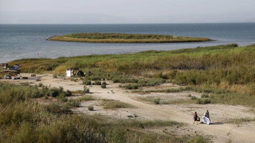 People gather near an island that was exposed due to low water level in the Sea of Galilee in northern Israel on August 30, 2018. (Photo by AHMAD GHARABLI / AFP)        (Photo credit should read AHMAD GHARABLI/AFP via Getty Images)
