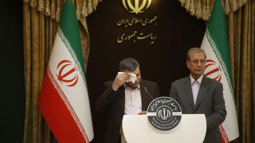 Iranian Deputy Health Minister Iraj Harirchi (L) wipes the sweat off his face, during a press conference with the Islamic republic's government spokesman Ali Rabiei in the capital Tehran on February 24, 2020. - Iran's deputy health minister confirmed on February 25, that he has tested positive for the novel coronavirus, amid a major outbreak in the Islamic republic. Harirchi coughed occasionally and appeared to be sweating during the press conference with Rabiei in Tehran. (Photo by Mehdi BOLOURIAN / FARS N