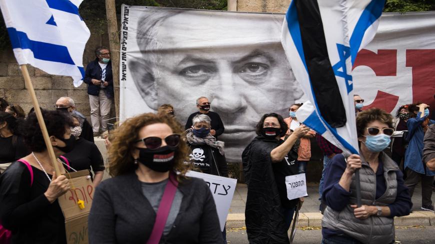 JERUSALEM, ISRAEL - MAY 24: Israelis hold flags and signs as they protest against Israeli Prime Minister, Benjamin Netanyahu on May 24, 2020 in Jerusalem, Israel. The prime minister, who strongly denies the charges of bribery, fraud and breach of trust, was recently sworn in to office at the head of a national unity government formed with his opponent Benny Gantz. (Photo by Amir Levy/Getty Images)