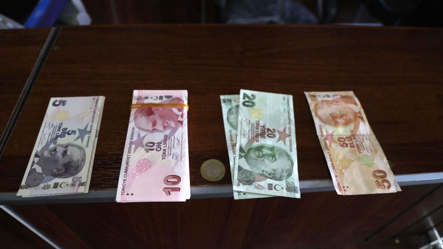 Turkish lira banknotes are pictured at a bank in the town of Sarmada in Syria's northwestern Idlib province, on June 14, 2020. - Authorities in northwest Syria are taking steps to substitute the plummeting Syrian pound with the Turkish lira to shield their opposition-held region from an economic crisis ahead of new US sanctions, an official said. The Salvation Government -- a civilian body affiliated to the Hayat Tahrir al-Sham jihadist group which dominates the Idlib region -- had already started paying wa
