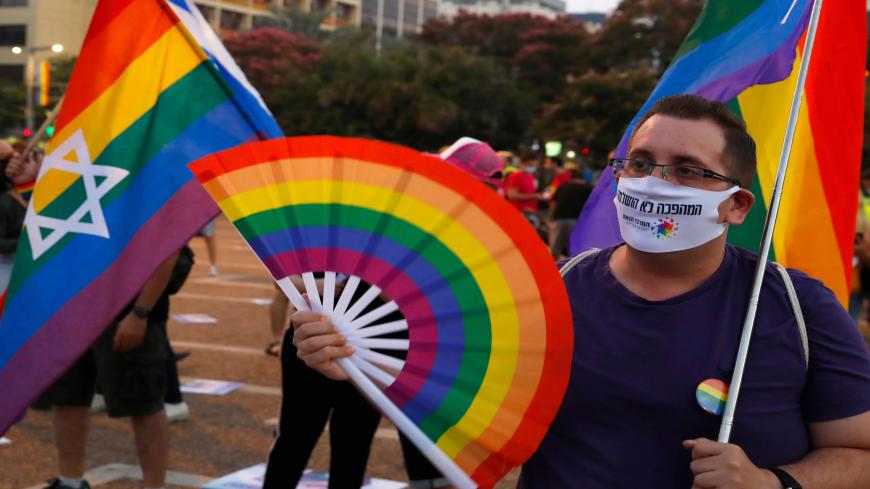 Participants hold rainbow flags as they take part in Tel Aviv's annual Pride Parade amid the COVID-19 pandemic, on June 28, 2020. - Thousands took part in muted LGBT events across Israel today as the usually larger gatherings were cancelled due to coronavirus restrictions. In Tel Aviv, home to the Middle East's biggest annual Pride parade, revellers gathered at Rabin Square for a concert featuring local stars including transgender Eurovision winner Dana International. (Photo by JACK GUEZ / AFP) (Photo by JA