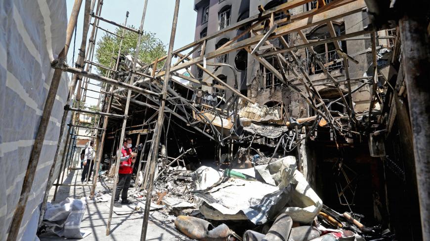 Iranian security and rescue staff work at the site of an explosion at the Sina At'har health centre in the upmarket northern neighbourhood of Tajrish in the capital Tehran on July 1, 2020. - Iranian police questioned four people as part of investigations into a powerful explosion that killed 19 people at a Tehran clinic the night before, state media reported. (Photo by ATTA KENARE / AFP) (Photo by ATTA KENARE/AFP via Getty Images)