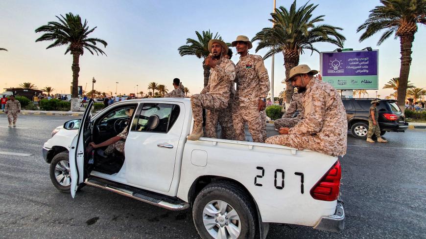 Members of the "Tripoli Brigade", a militia loyal to the UN-recognised Government of National Accord (GNA), sit in the back of a pickup truck as they parade through the Martyrs' Square at the centre of the GNA-held Libyan capital Tripoli on July 10, 2020. (Photo by Mahmud TURKIA / AFP) (Photo by MAHMUD TURKIA/AFP via Getty Images)