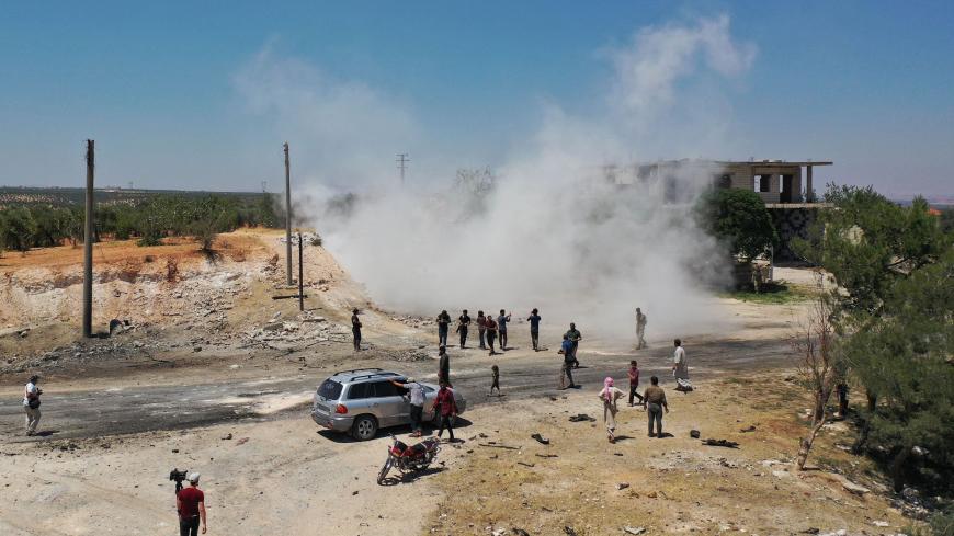 An aerial picture shows Syrians gathering at the site of an improvised explosive device which hit a joint Turkish-Russian patrol on the strategic M4 highway, near the Syrian town of Ariha in the rebel-held northwestern Idlib province, on July 14, 2020. - Three Russian and several Turkish soldiers were wounded in Syria's restive Idlib province when a joint military patrol was hit by an improvised explosive device, Russia's defence ministry said. (Photo by Omar HAJ KADOUR / AFP) / The erroneous photographer's