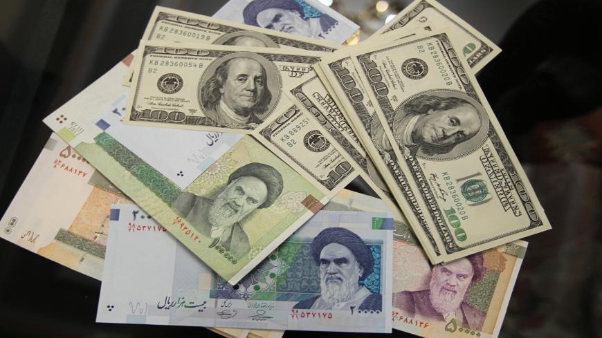 The picture illustrates United States 100-dollar bills bearing the portrait of US statesman, inventor and diplomat Benjamin Franklin next to Iran's various Rial banknotes, bearing a portrait of Iran's late founder of Islamic Republic Ayatollah Ruhollah Khomeini in Tehran on January 18, 2012. The Rial's plunge, to 18,000 to the dollar hit a record low on January 18, based on rates in black market trading that the government has tried to ban. AFP PHOTO/ATTA KENARE (Photo credit should read ATTA KENARE/AFP via