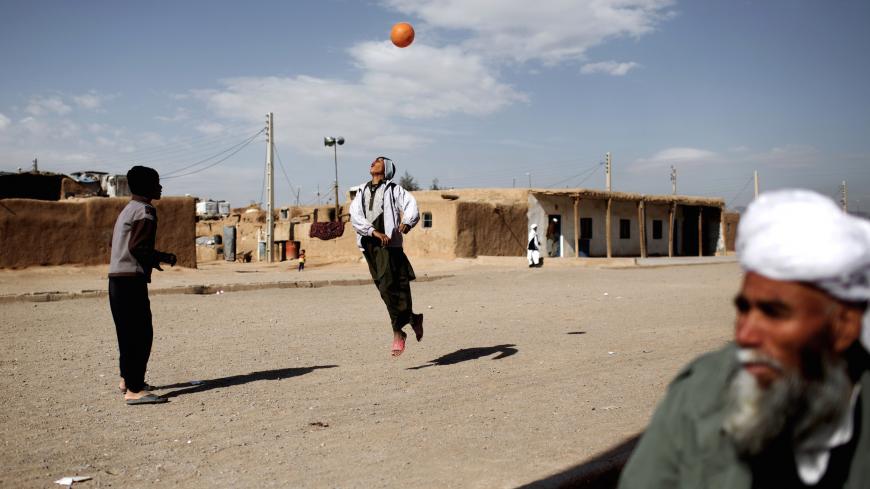 Afghan boys play football at the Shahid Nasseri refugee camp in Taraz Nahid village near the city of Saveh, some 130 kms southwest of the capital Tehran, on February 8, 2015. Some 5000 Afghan refugees live at the camp which is run by the Iranian Bureau for Aliens and Foreign Immigrants' Affairs (BAFIA), the World Food Program (WFP) and UNHCR. According to the United Nations High Commissioner for Refugees (UNHCR), there are 950,000 registered Afghan residents in Iran -- some of whom have never even set foot 