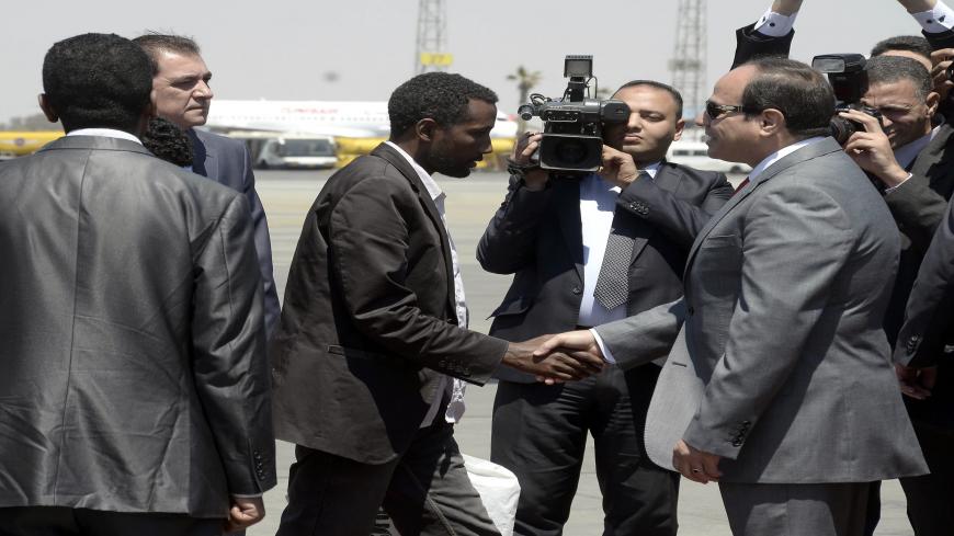 Egyptian President Abdel Fattah al-Sisi (R) receives an Ethiopian man who Sisi said was "rescued" from war-torn Libya alongside 26 of his compatriots by Egypts security services upon their arrival at Cairo airport on May 7, 2015. It was not immediately clear how the Ethiopians were rescued, but Sisi's office said the group flown in on an Egyptian plane was "liberated by Egyptian and Libyan security services". AFP PHOTO / STR        (Photo credit should read STR/AFP via Getty Images)