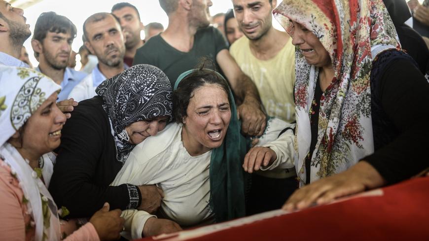 The mother of a victim (C) cries for her son on his coffin during a funeral ceremony in Gaziantep on July 21, 2015, following a suicide bomb attack the day before which killed at least 31 in the southern Turkish town of Suruc. A suspected Islamic State suicide bomber killed at least 31 people in an attack on a Turkish cultural centre in the southern town of Suruc, where activists had gathered to prepare for an aid mission in the nearby Syrian town of Kobane. It was one of the deadliest attacks in Turkey in 