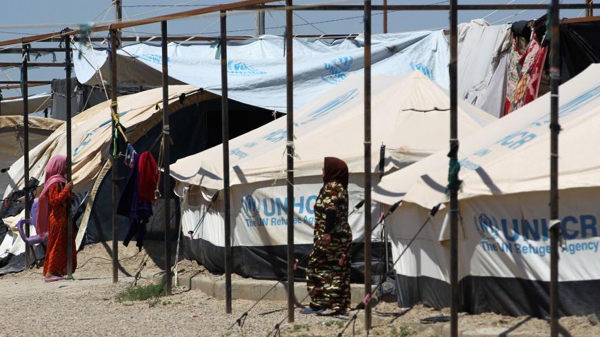 Displaced Iraqi women walk in a camp for internally displaced people near al-Khalidiyeh in Iraq's western Anbar province on April 24, 2018. - While the election campaign is in full swing elsewhere in Iraq, the country's displaced camps barely register on the radars of those running for office, despite housing hundreds of thousands of people. (Photo by AHMAD AL-RUBAYE / AFP)        (Photo credit should read AHMAD AL-RUBAYE/AFP via Getty Images)