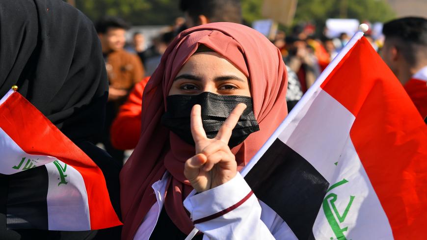 An Iraqi student, holding a national flag, flashes the V-sign for victory during anti-government protests in the Shiite shrine city of Najaf in central Iraq on January 28, 2020. - Rallies first erupted in Baghdad and across Iraq's Shiite-majority south on October 1 over a lack of jobs, poor services and corruption but are now specifically demanding snap elections, an independent premier and the prosecution of those implicated in corruption or recent bloodshed. (Photo by Haidar HAMDANI / AFP) (Photo by HAIDA