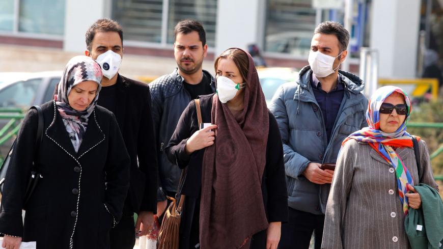 Iranians, some wearing protective masks, wait to cross a street in the capital Tehran on February 22, 2020. - Iran today reported one more death among 10 new cases of coronavirus, bringing the total number of deaths in the Islamic republic to five and infections to 28. (Photo by ATTA KENARE / AFP) (Photo by ATTA KENARE/AFP via Getty Images)