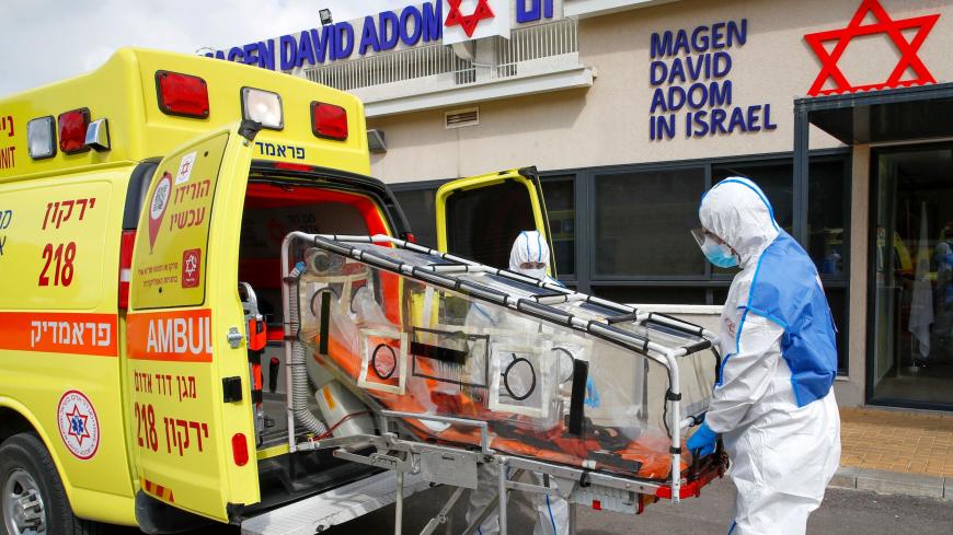 Israeli Paramedics of Maguen David Adom (Israel's National Emergency Pre-Hospital Medical Organisation) at the coronavirus national operations center unload a containment chamber during a coronavirus response training exercise in the central Israeli city of Kiryat Ono on February 26, 2020. - Some 80,000 people are infected worldwide, including nearly 2,800 outside China, and more than 2,700 have died worldwide, according to the latest toll from the World Health Organization. (Photo by JACK GUEZ / AFP) (Phot