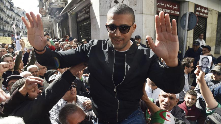 A picture taken on March 6, 2020 shows Algerian protesters carrying journalist Khaled Drareni on their shoulders after he was briefly detained by security forces in the Algerian capital Algiers. - Drareni was arrested on March 7 while covering an anti-government protest, accused of "inciting an unarmed gathering and damaging national integrity". (Photo by RYAD KRAMDI / AFP) (Photo by RYAD KRAMDI/AFP via Getty Images)