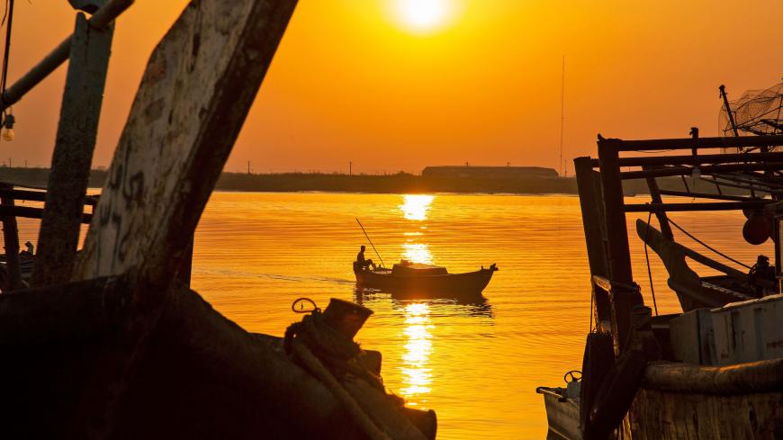 A man sits in fishing boat in the water of Shatt al-Arab in Iraq's southern port city of al-Faw, 90 kilometres south of Basra near the Gulf, on May 18, 2020. - In Iraq, a national lockdown to halt the COVID-19 coronavirus pandemic has found some unexpected fans: local businesses who no longer have to compete with Turkish, Iranian or Chinese imports. Those countries, as well as Saudi Arabia, Jordan and Kuwait, typically flood Iraqi markets with inexpensive products at prices local producers can't compete wit