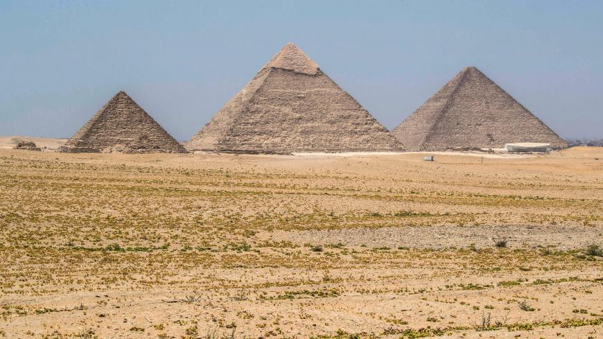 This picture taken on July 1, 2020 shows a general view of (R to L) the Great Great Pyramid of Khufu (Cheops), the Pyramid of Khafre (Chephren), and the Pyramid of Menkaure (Menkheres) at the Giza Pyramids necropolis on the southwestern outskirts of the Egyptian capital Cairo, as the archaeological site reopens while the country eases restrictions put in place due to the COVID-19 coronavirus pandemic. - A spree of openings in Egypt comes after the country officially ended a three-month nighttime curfew a fe