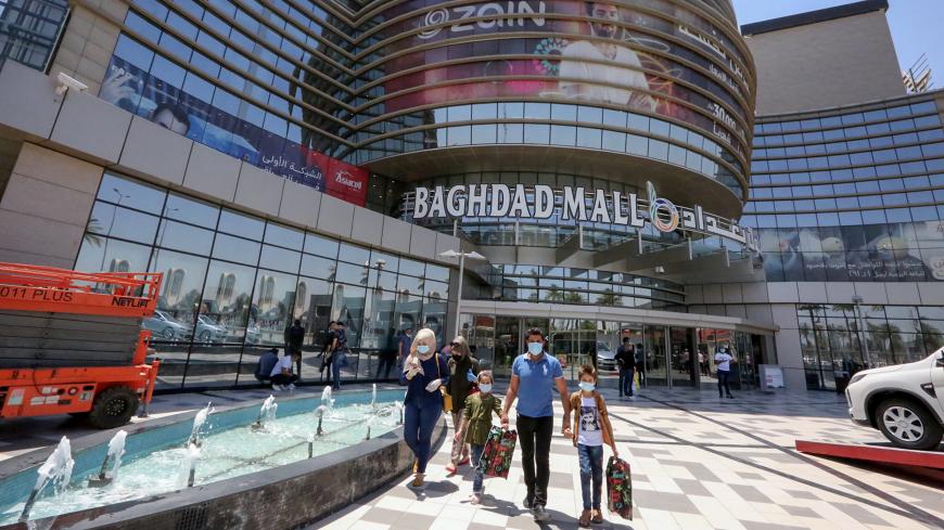 Iraqis wearing protective masks leave after shopping at the Mall of Baghdad as it reopens after a long closure due to the COVID-19 pandemic, in the Al-Harithiya area of the capital Baghdad, on July 19, 2020. (Photo by SABAH ARAR / AFP) (Photo by SABAH ARAR/AFP via Getty Images)