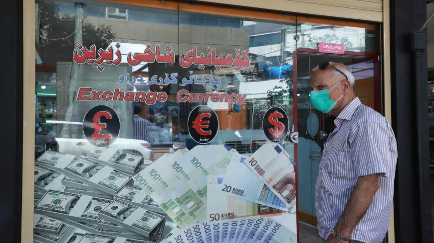 An Iraqi man, wearing a protective mask due to the COVID-19 pandemic, stands at the entrance of a money exchange office in Sulaimaniyah city in the Kurdish autonomous region of northern Iraq on August 4, 2020. - In Iraq's Kurdistan and holy Shiite sites, trading US dollars for rials from Iran was once big business with millions of pilgrims and for businessmen coming to visit. But the money exchange business has been hard hit by lockdown restrictions to stop the spread of COVID-19. (Photo by Shwan MOHAMMED /