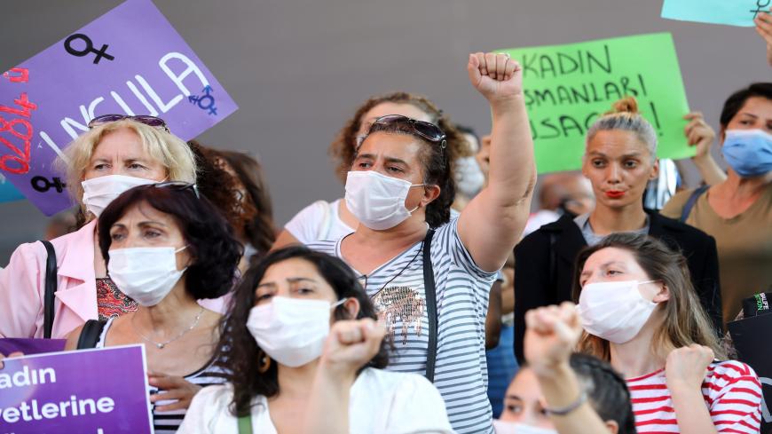 A woman wearing a face mask raises her fist in Ankara, on August 5, 2020, during a demonstration to demand the government does not withdraw from the Istanbul Conventio, a landmark treaty, on preventing domestic violence. - The protests were the biggest in recent weeks as anger grows over the rising number of women killed by men in the past decade since the Istanbul Convention. The treaty's official title is the Council of Europe Convention on preventing and combating violence against women and domestic viol