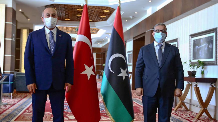 Turkish Foreign Minister Mevlut Cavusoglu (L) poses with the President of the Libyan Supreme Council of State Khalid Al-Mishri prior to a meeting in Libya's capital Tripoli, on August 6, 2020. (Photo by - / AFP) (Photo by -/AFP via Getty Images)