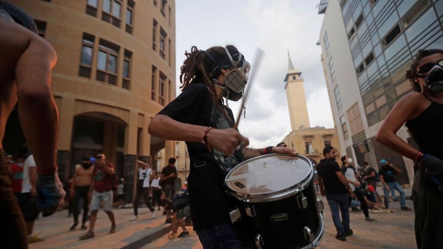 TOPSHOT - A Lebanese protester beats a drum amid clashes with security forces near an access street to the parliament in central Beirut on August 9, 2020, following a deadly explosion that turned the city into a disaster zone. - The huge chemical explosion that hit Beirut's port, devastating large parts of the Lebanese capital and claiming over 150 lives, left a 43-metre (141 foot) deep crater, a security official said. (Photo by JOSEPH EID / AFP) (Photo by JOSEPH EID/AFP via Getty Images)