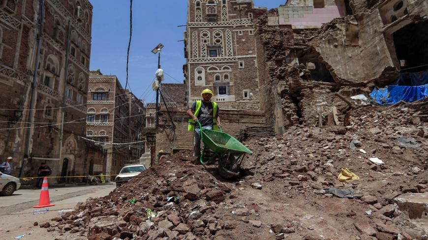A Yemeni labourer removes the rubble ahead of restoration works on the site of a collapsed UNESCO-listed building following heavy rains, in the old city of the Yemeni capital Sanaa, on August 12, 2020. - Flash floods triggered by torrential rains have killed at least 172 people across Yemen over the past month, damaging homes and UNESCO-listed world heritage sites, officials said. (Photo by Mohammed HUWAIS / AFP) (Photo by MOHAMMED HUWAIS/AFP via Getty Images)